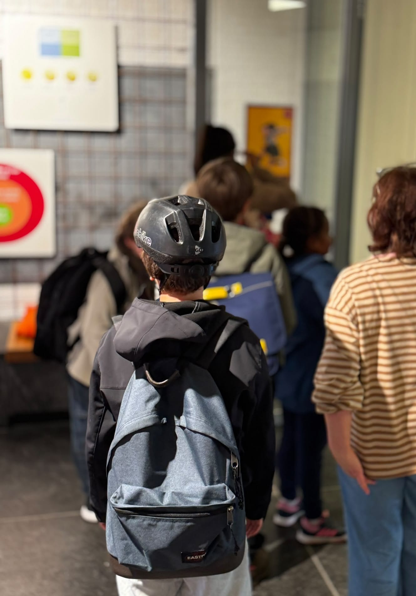 Kinderen met rugzakken lopen na de plusklas naar buiten